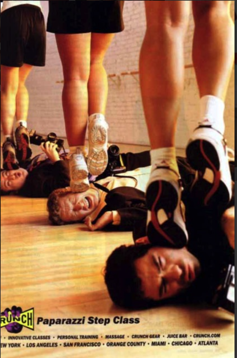 A step class features women exercising on men's heads